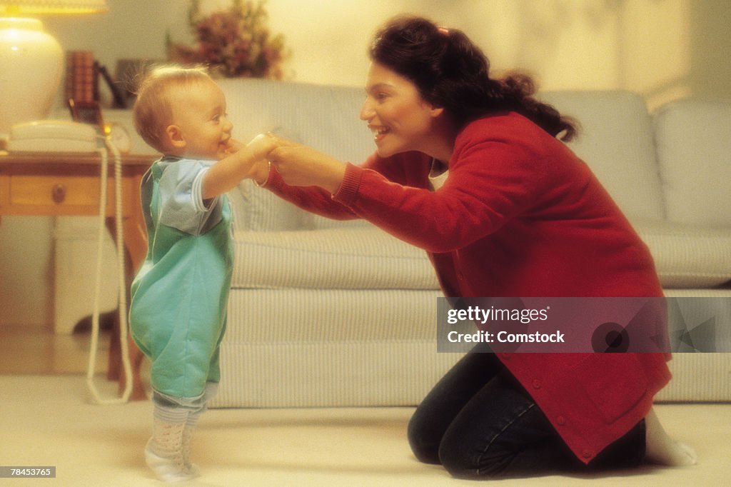 Mother with baby taking first steps