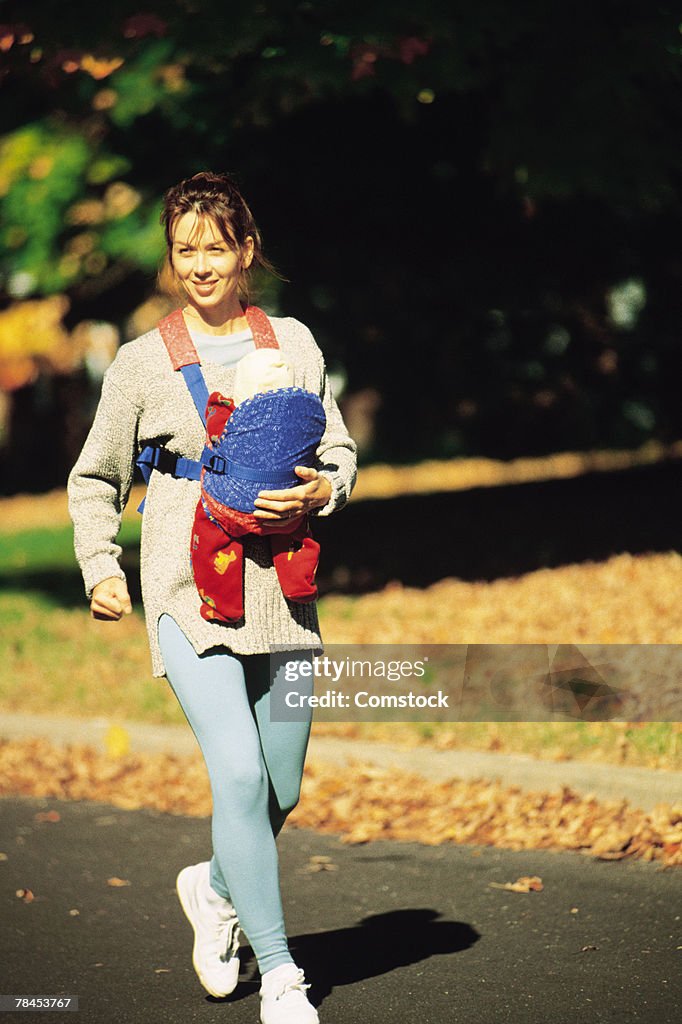 Mother walking briskly while carrying baby