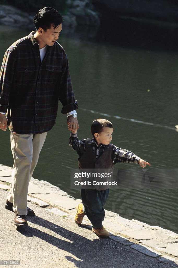 Father and son walking alongside a lake