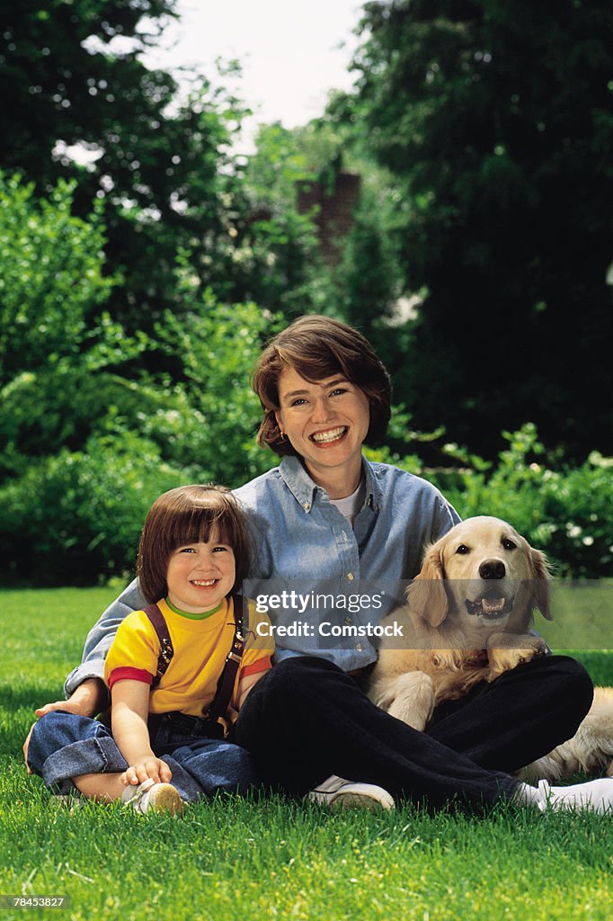 Portrait of mother and son with dog outdoors