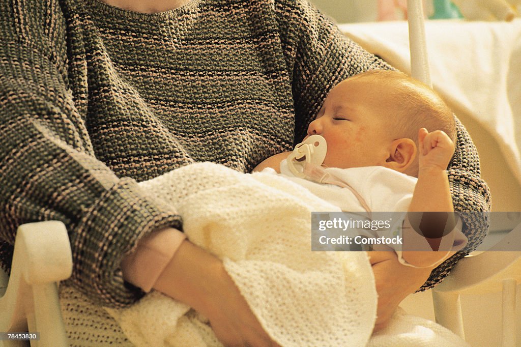 Mother holding sleeping baby