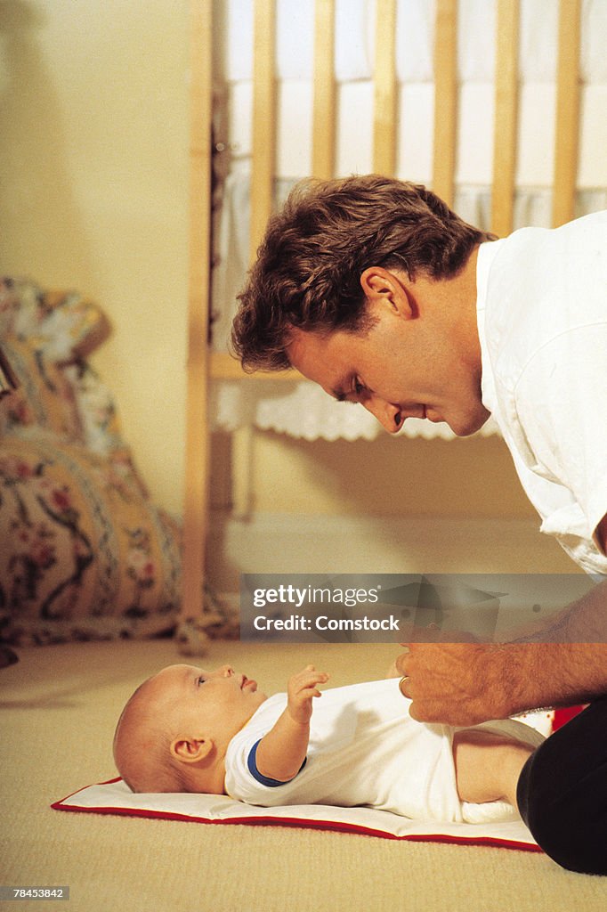 Father changing baby's diaper