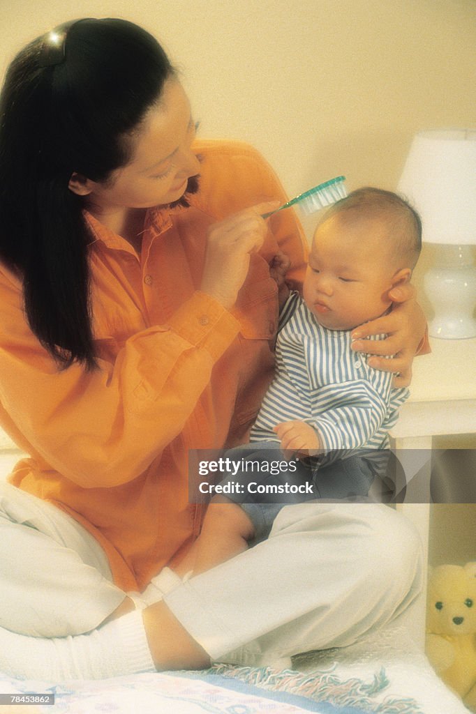 Mother brushing baby's hair