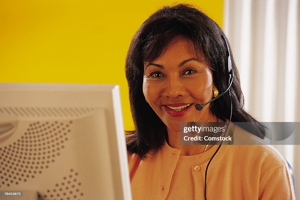 Woman at computer with headset