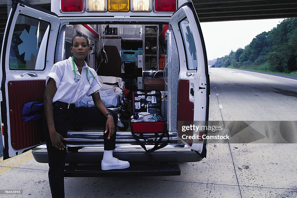 Emergency medical technician posing at back of ambulance
