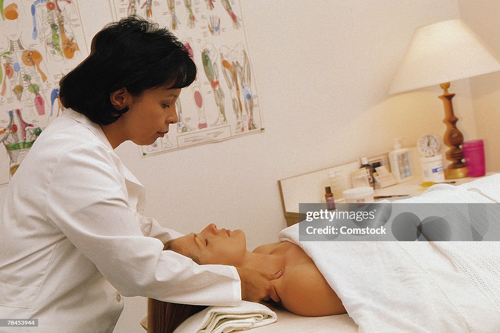 Female chiropractor massaging a patient