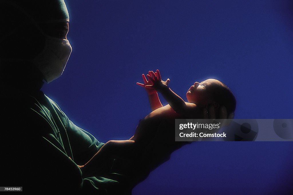 Doctor holding newborn baby