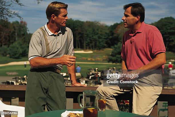 men on balcony overlooking golf course - sportverein stock-fotos und bilder