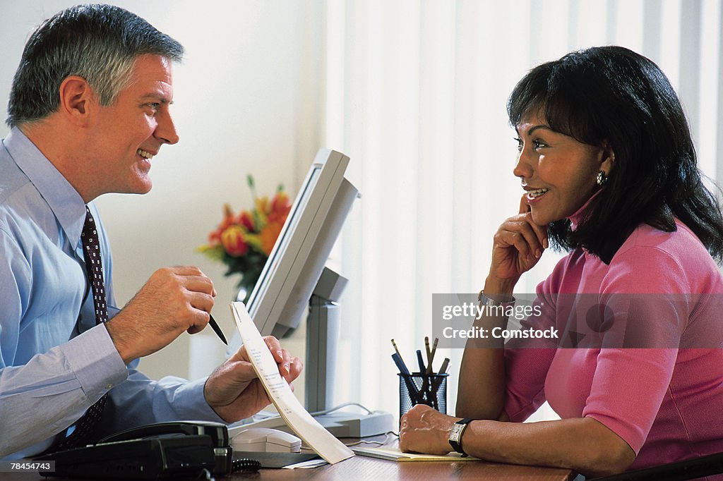 Businessman explaining document to woman