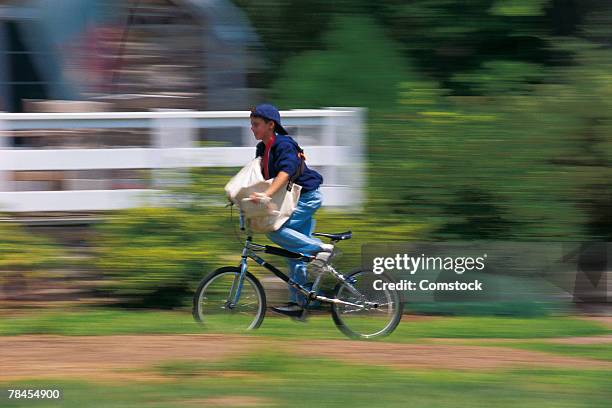 boy riding his bike on paper route - repartidor de periódicos fotografías e imágenes de stock