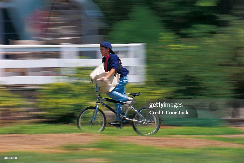 Boy riding his bike on paper route