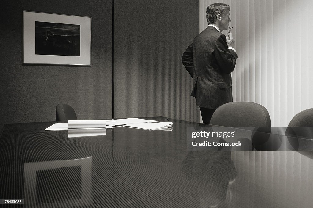 Executive standing in conference room