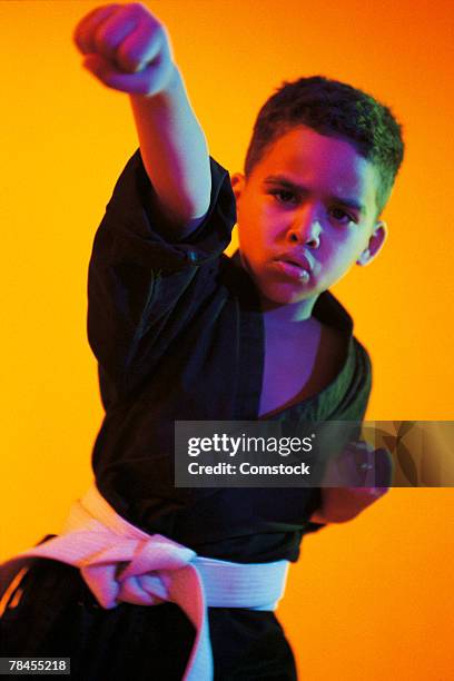 boy in action pose in karate attire - kid punching stock pictures, royalty-free photos & images