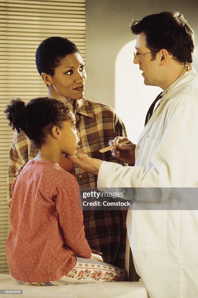 Mother and daughter at doctor's office with pediatrician