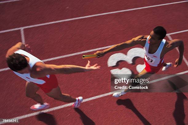men passing baton in relay race - stafett bildbanksfoton och bilder