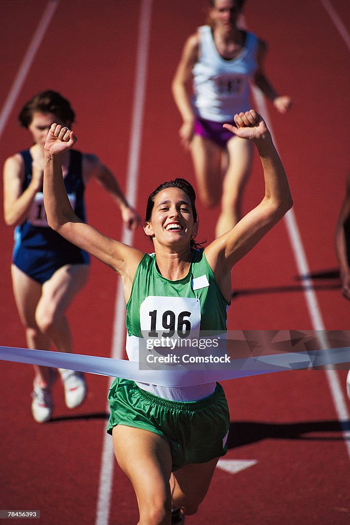 Woman winning race at track meet