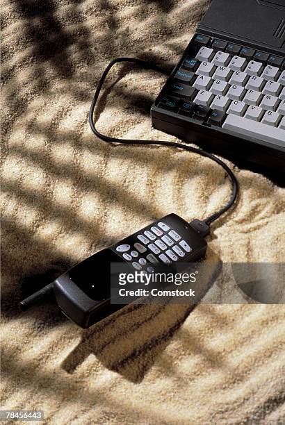 telephone connected to laptop computer in beach sand - 90s cell phone bildbanksfoton och bilder