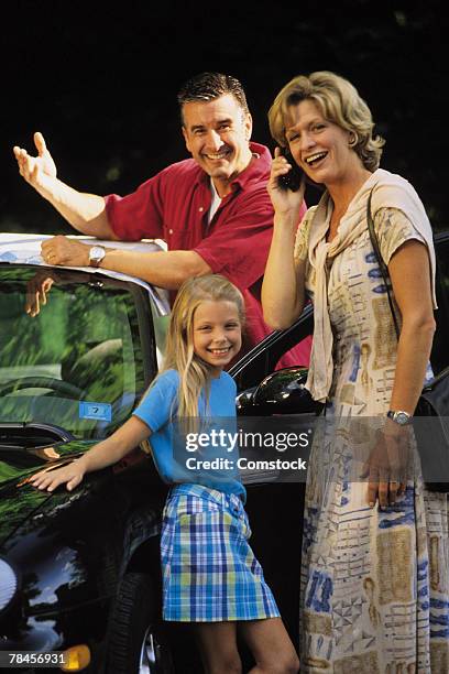 family standing by car , mother on cell phone - cell phone 90s stock pictures, royalty-free photos & images