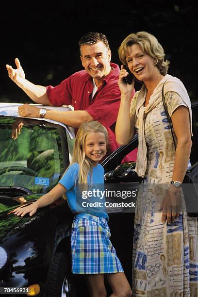 family standing by car , mother on cell phone - 90s cell phone bildbanksfoton och bilder