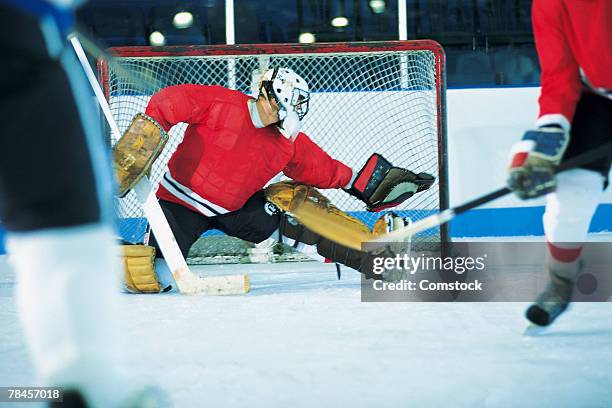 goalie making save in ice hockey game - portiere giocatore di hockey su ghiaccio foto e immagini stock