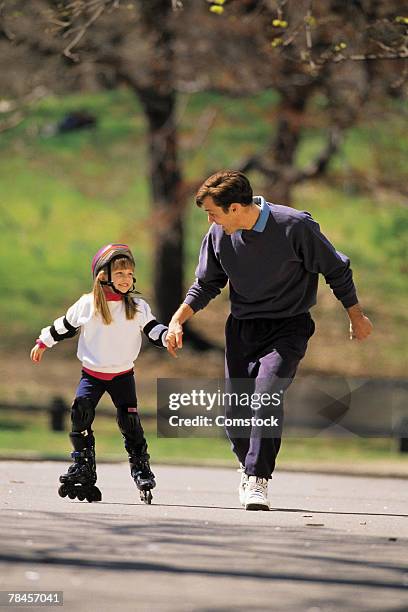 father helping daughter on inline skates - 90s rollerblading fotografías e imágenes de stock