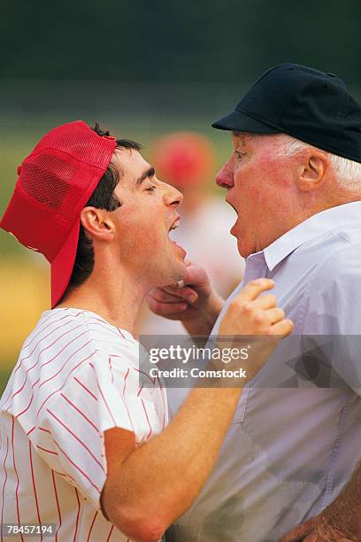 baseball player arguing with umpire - sports official foto e immagini stock