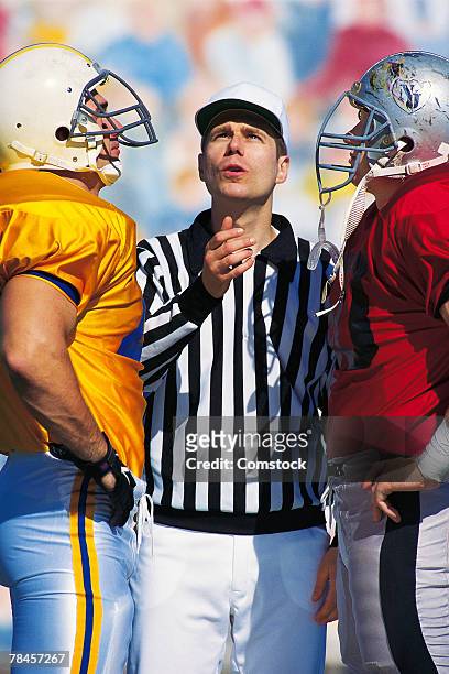referee flipping coin at start of football game - flipping a coin stock pictures, royalty-free photos & images