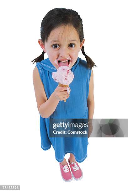 girl in blue dress eating ice cream cone - girl eating messy ice cream cone stock-fotos und bilder
