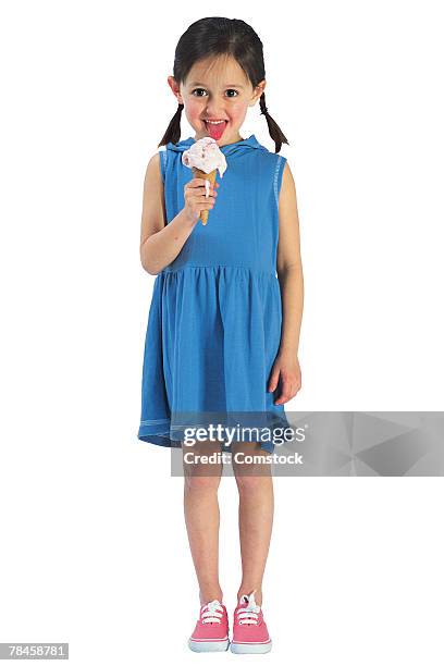 girl in blue dress eating ice cream cone - girl eating messy ice cream cone stock-fotos und bilder