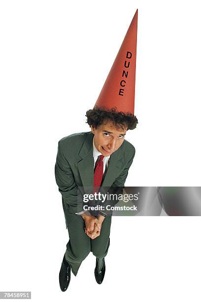 businessman wearing dunce cap - dunce cap stock-fotos und bilder