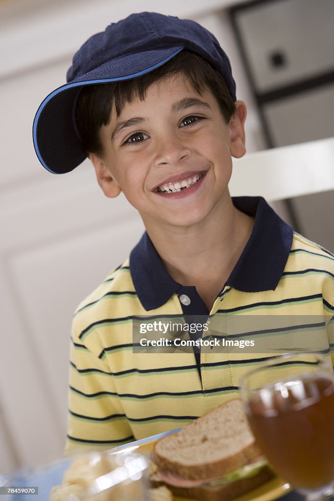 Boy wearing baseball cap at lunch