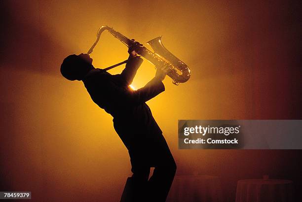 silhouette of man playing saxophone - 木管楽器 ストックフォトと画像