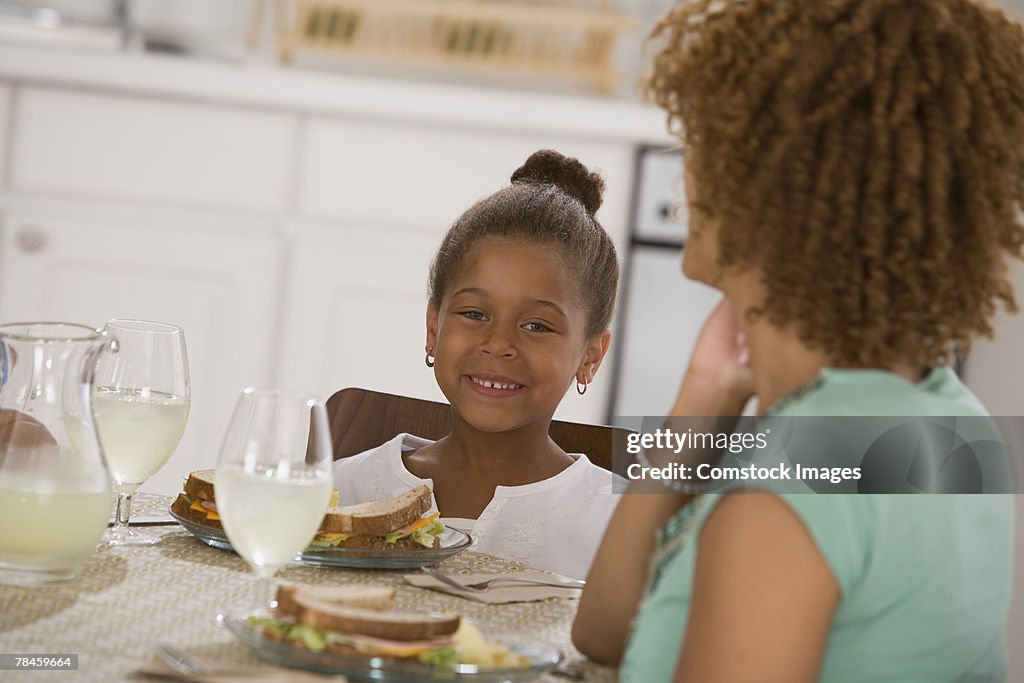 Child sitting at table with woman