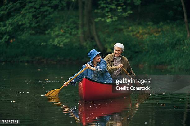 retired couple canoeing - two people canoeing on a lake stock pictures, royalty-free photos & images