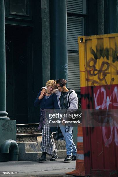 hispanic teen couple walking down alley - goth boy stock-fotos und bilder