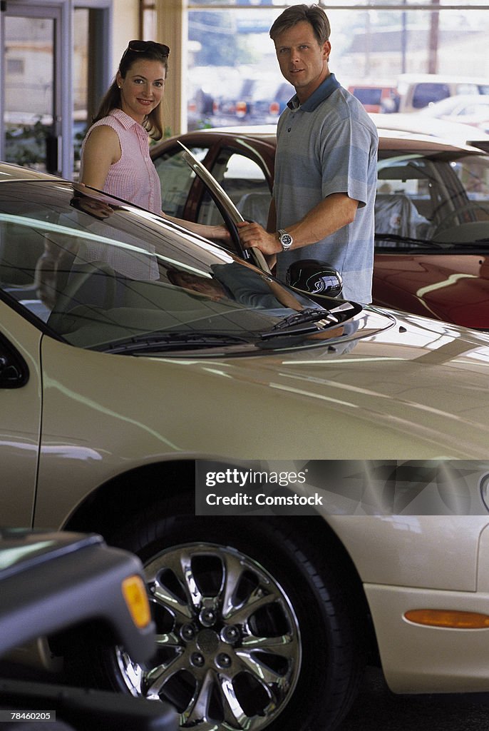 Couple looking at vehicle at car dealership