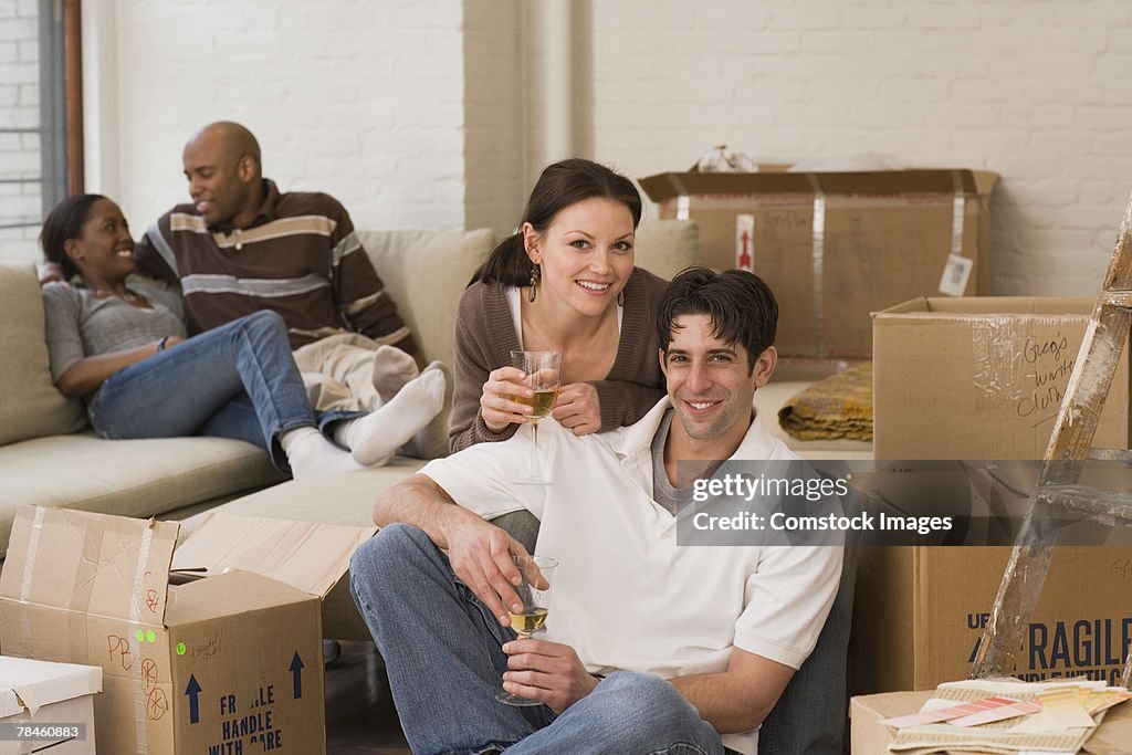 Couple with glasses of wine and packed boxes