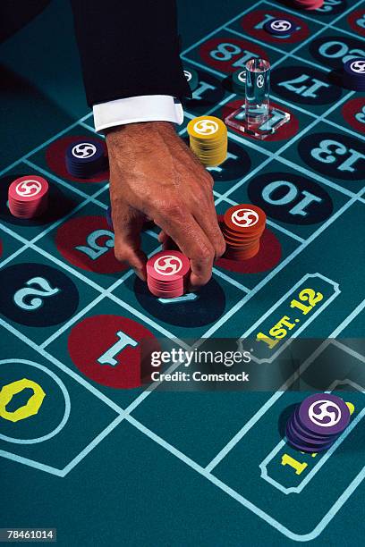 businessman placing chips on craps table - クラップス ストックフォトと画像