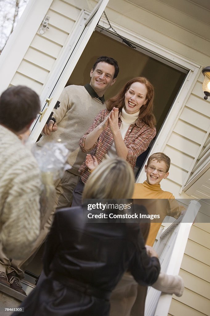 Family greeting visitors on porch