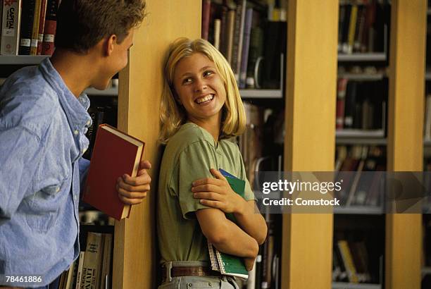 students flirting in library - 90s teens stock-fotos und bilder