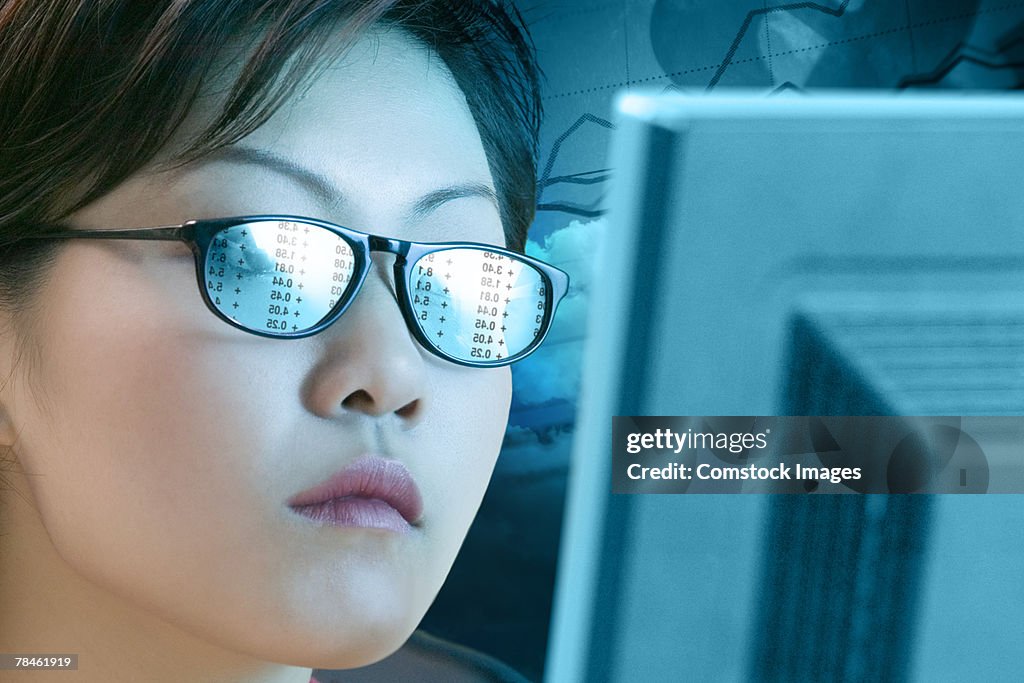 Woman with a reflection off a computer in her glasses