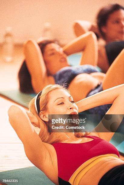 women doing crunches on floor mats - bauchmuskel stock-fotos und bilder
