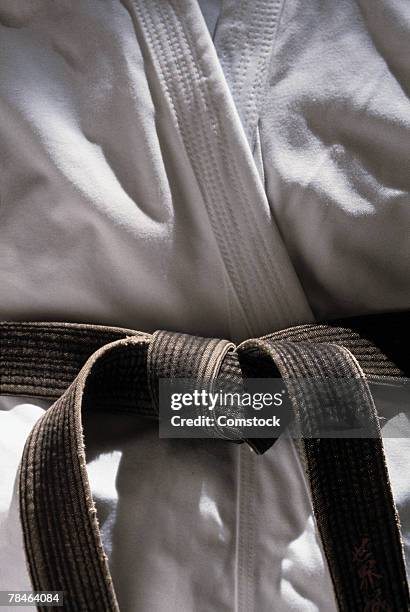 martial arts gi with black belt - gi abbigliamento per arti marziali foto e immagini stock