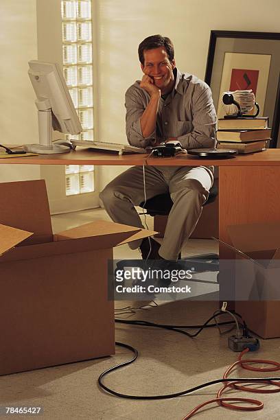 man sitting at desk surrounded by boxes - person surrounded by computer screens stock-fotos und bilder