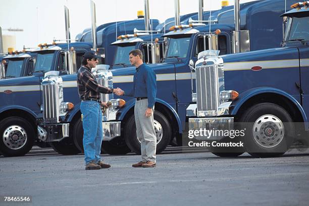 truck drivers shaking hands in parking lot - handshake fleet foto e immagini stock