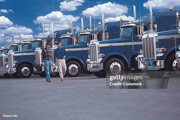 men walking by row of semi trucks - man talking to camera stock pictures, royalty-free photos & images