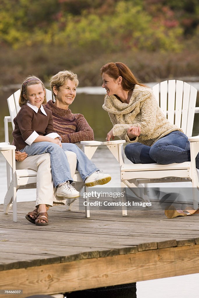 Three generations of women relaxing on pier together