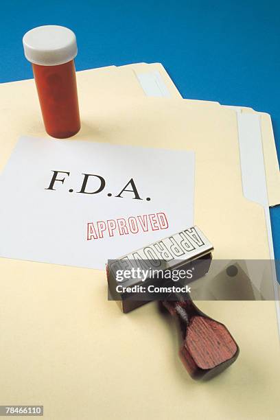 bottle on file folders with fda approved stamp - food and drug administration bildbanksfoton och bilder