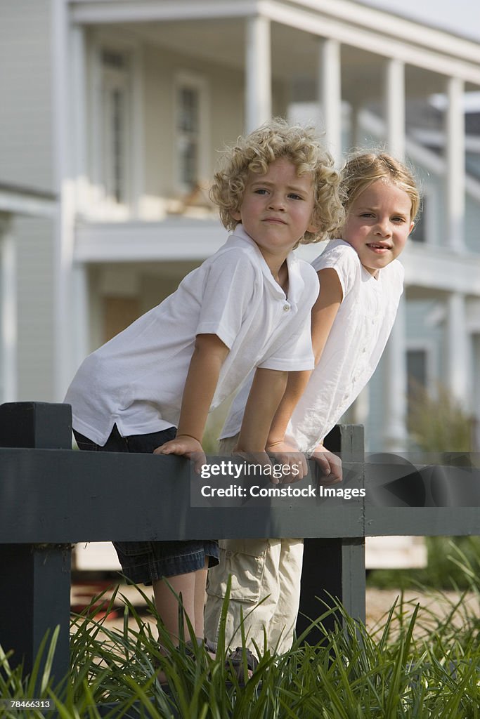 Boy and girl standing on fence