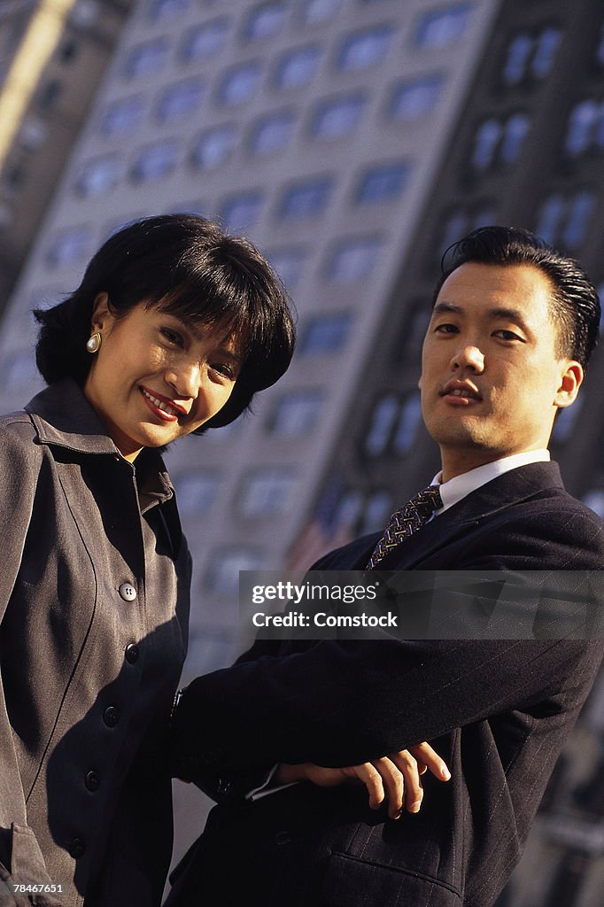 Portrait of businessman and woman in urban setting
